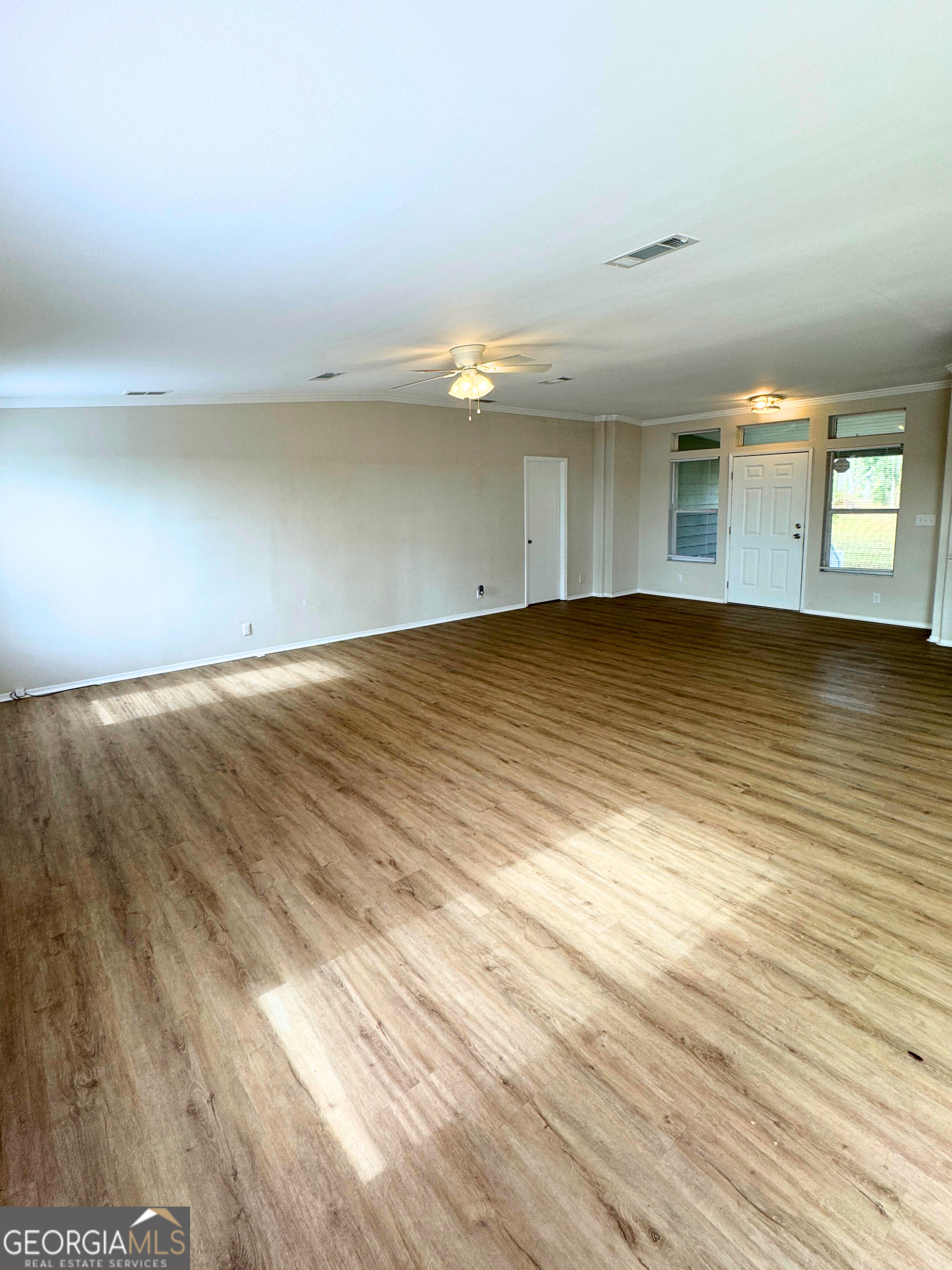 2554 Harrietts Bluff Road Woodbine, GA 31569 - Photo 8 of 35 an empty room with wooden floor and windows