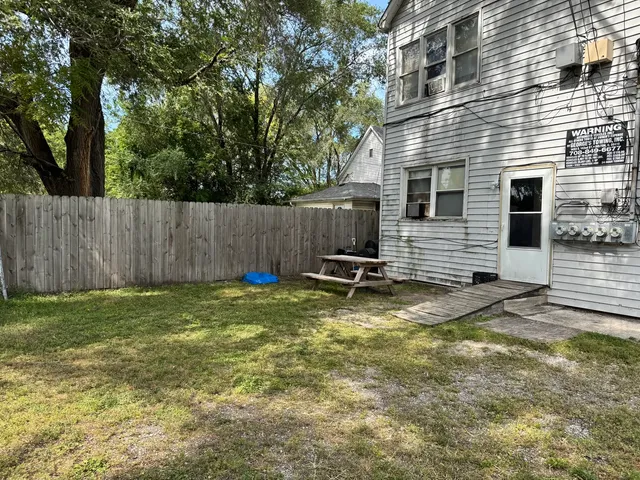 a view of a backyard with a table and chair and wooden fence
