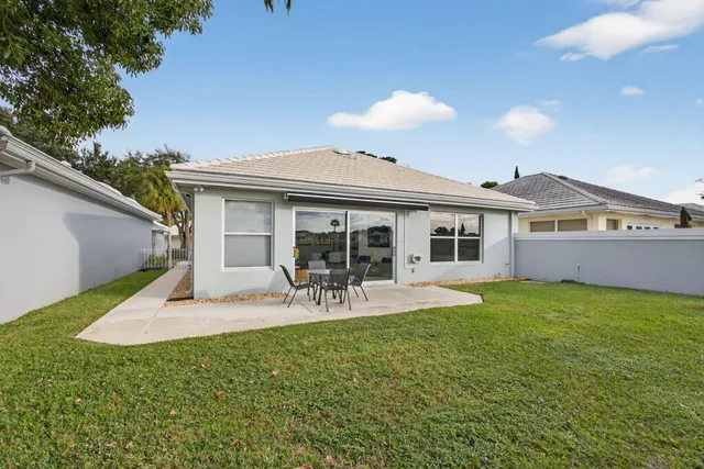 a front view of a house with a yard and potted plants
