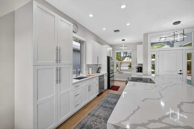 a large white kitchen with cabinets