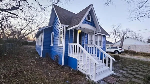 a view of a house with wooden fence