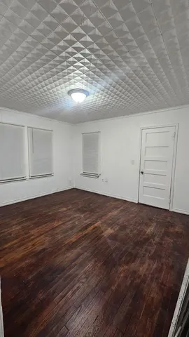 an empty room with wooden floor and cabinet