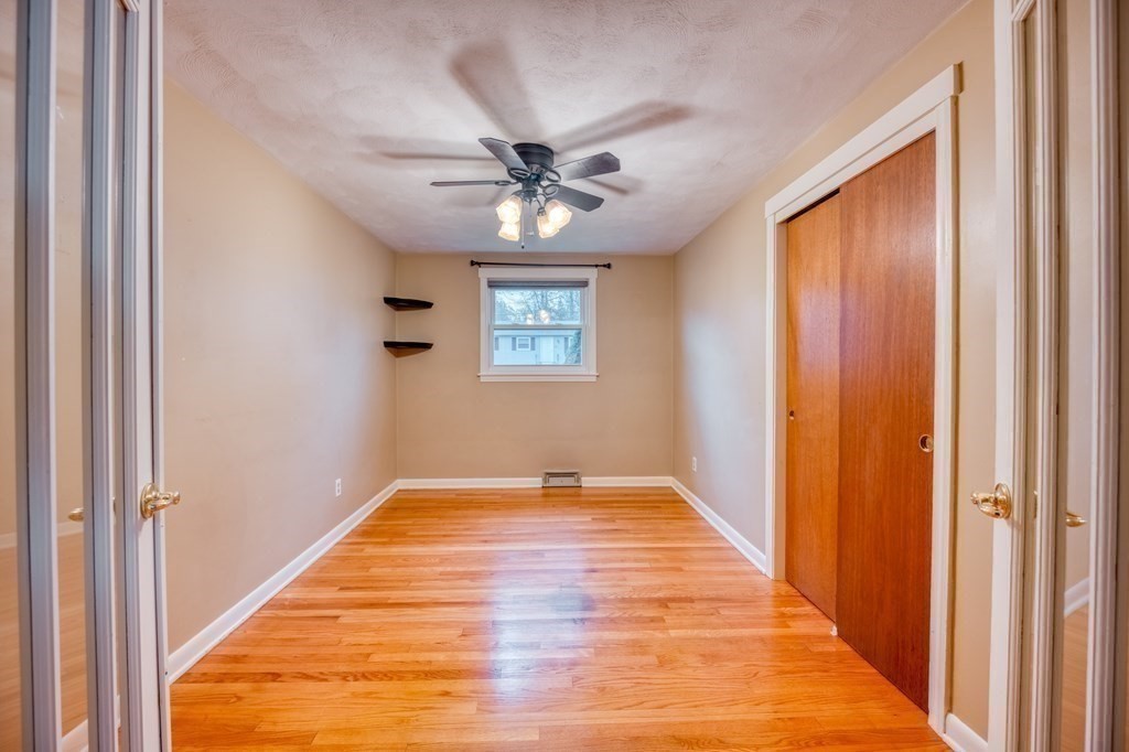 150 Louis Road Springfield, MA 01118 - Photo 19 of 39 a view of a hallway with a chandelier fan and wooden floor