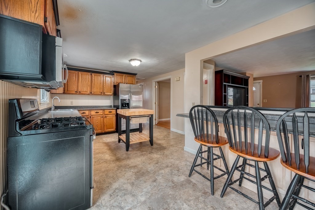 150 Louis Road Springfield, MA 01118 - Photo 7 of 39 a living room with furniture a flat screen tv and kitchen view