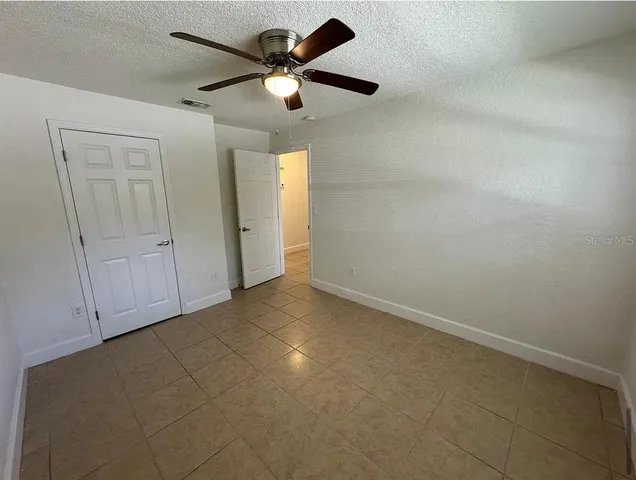 an empty room with a ceiling fan and a window