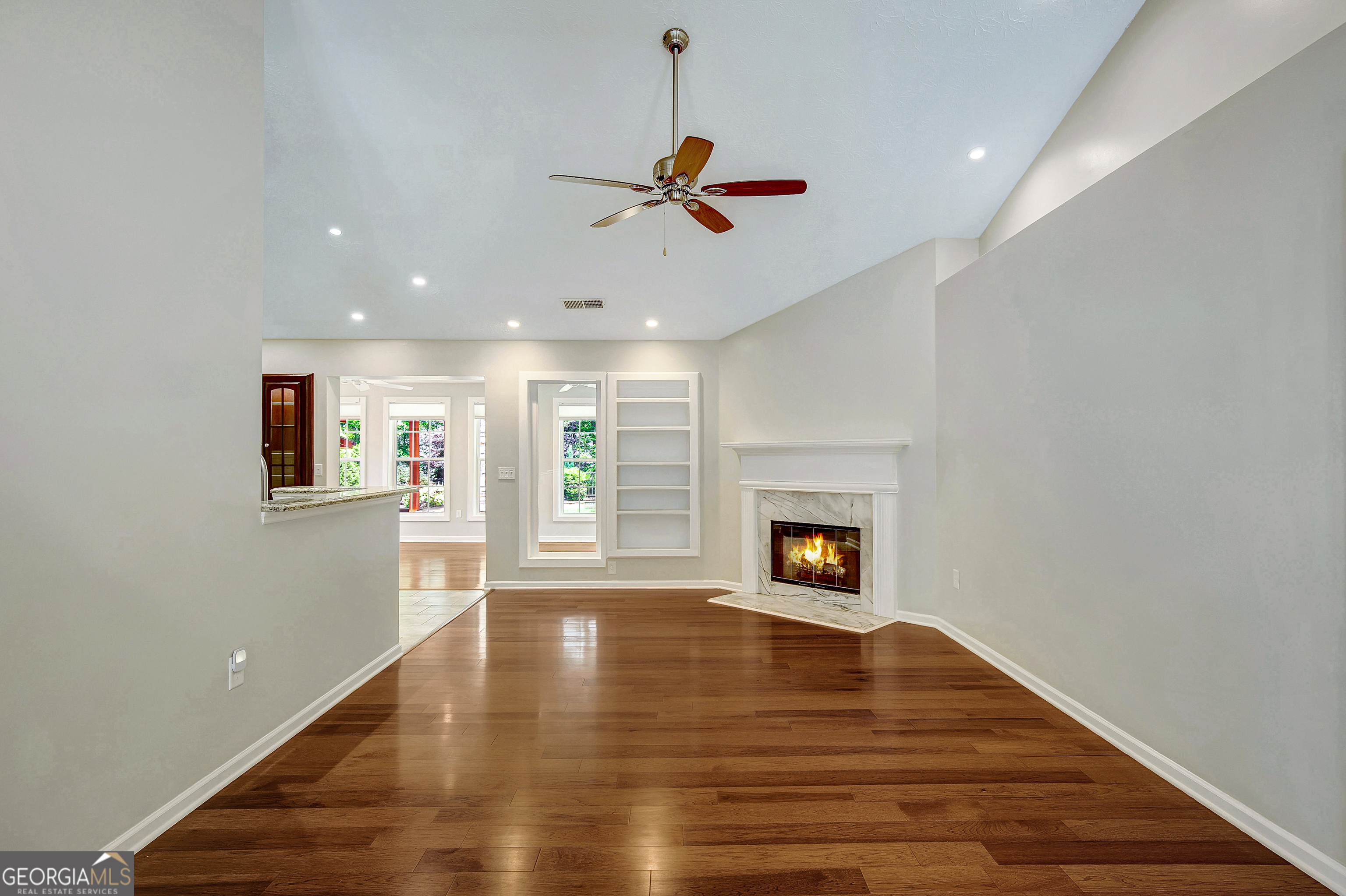 128 Lake Cove Approach Newnan, GA 30265 - Photo 18 of 63 a view of a livingroom with wooden floor a ceiling fan and windows
