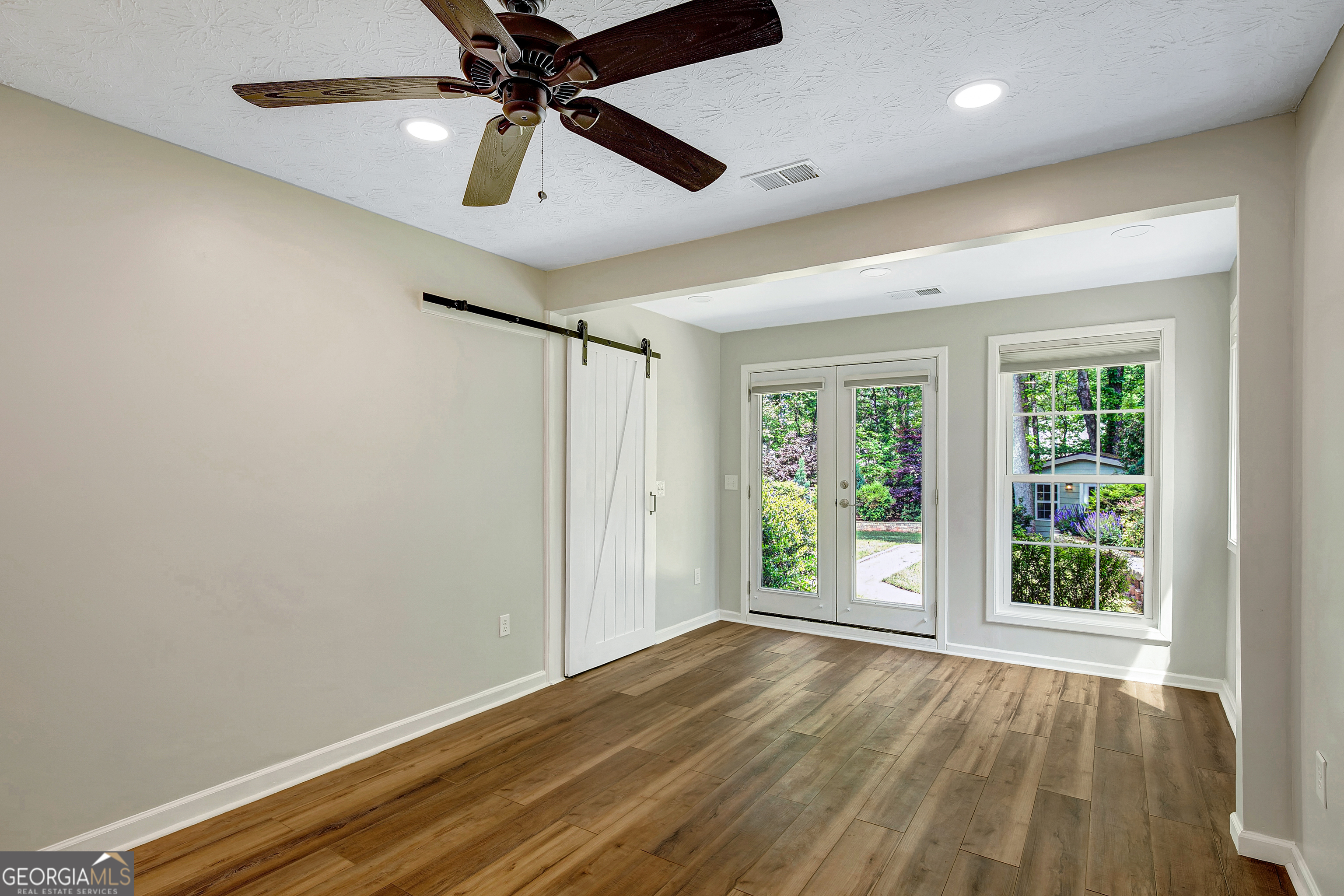 128 Lake Cove Approach Newnan, GA 30265 - Photo 26 of 63 an empty room with wooden floor fan and windows