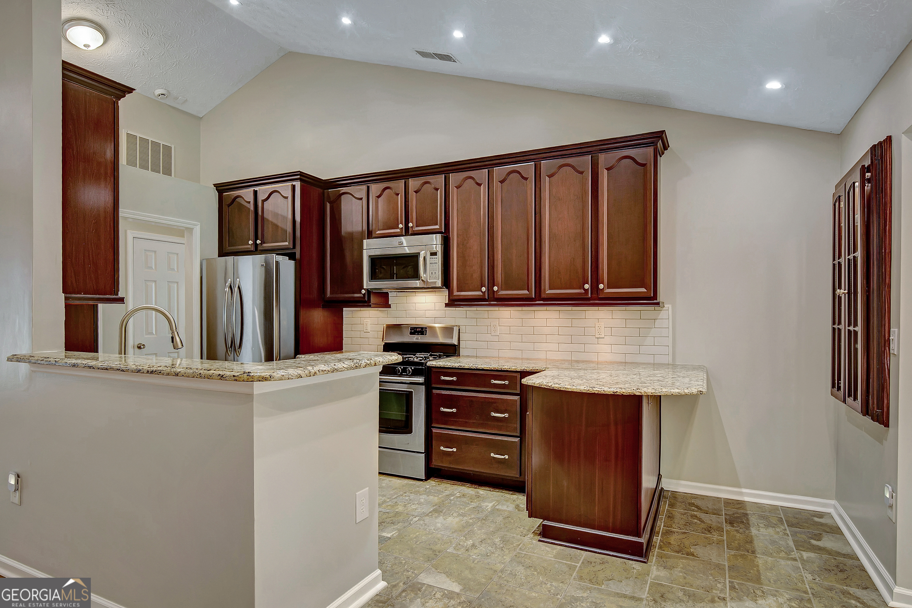 128 Lake Cove Approach Newnan, GA 30265 - Photo 30 of 63 a kitchen with stainless steel appliances granite countertop a refrigerator a stove top oven a sink and dishwasher