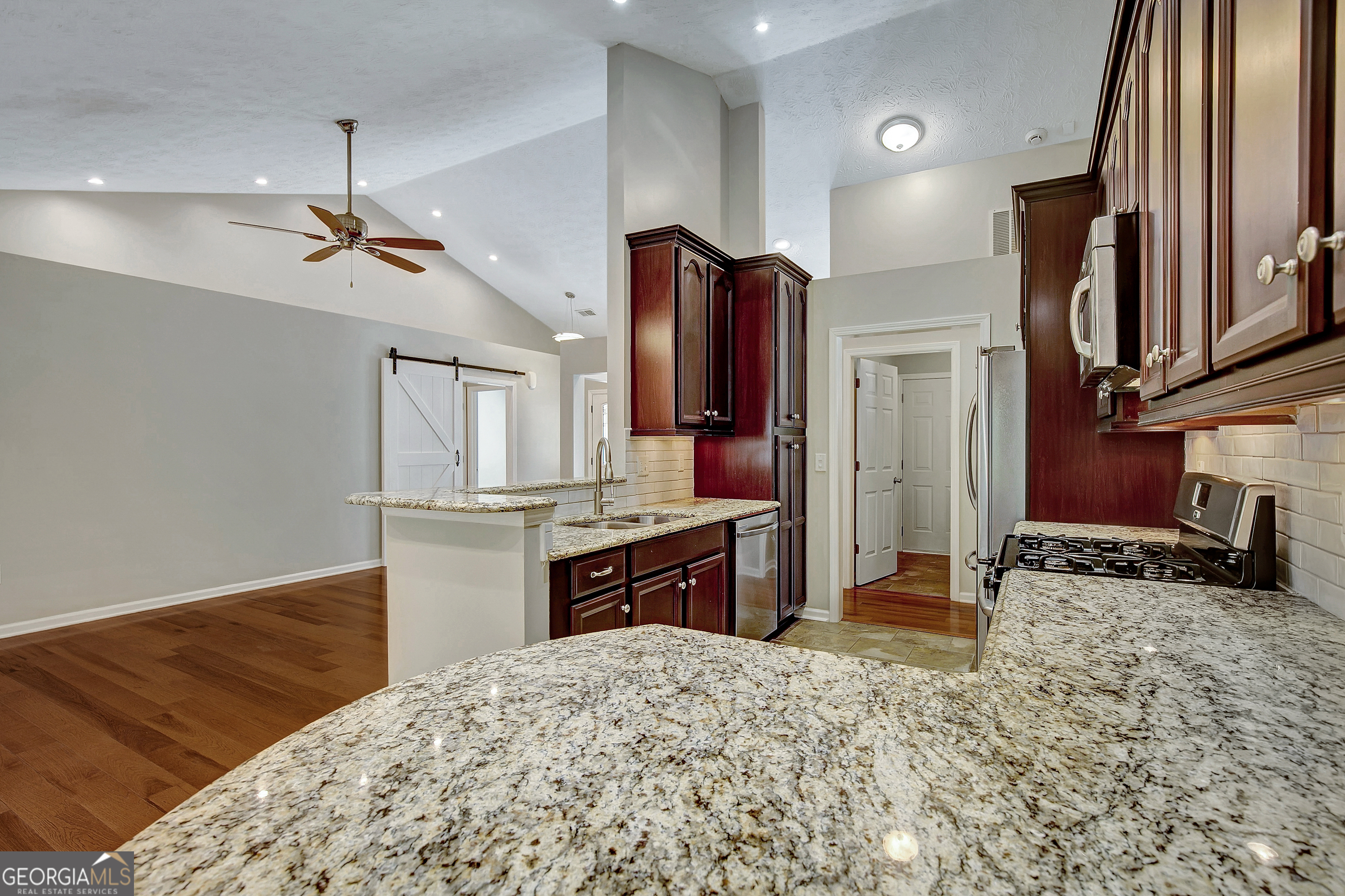 128 Lake Cove Approach Newnan, GA 30265 - Photo 31 of 63 a kitchen with stainless steel appliances granite countertop a sink refrigerator and cabinets