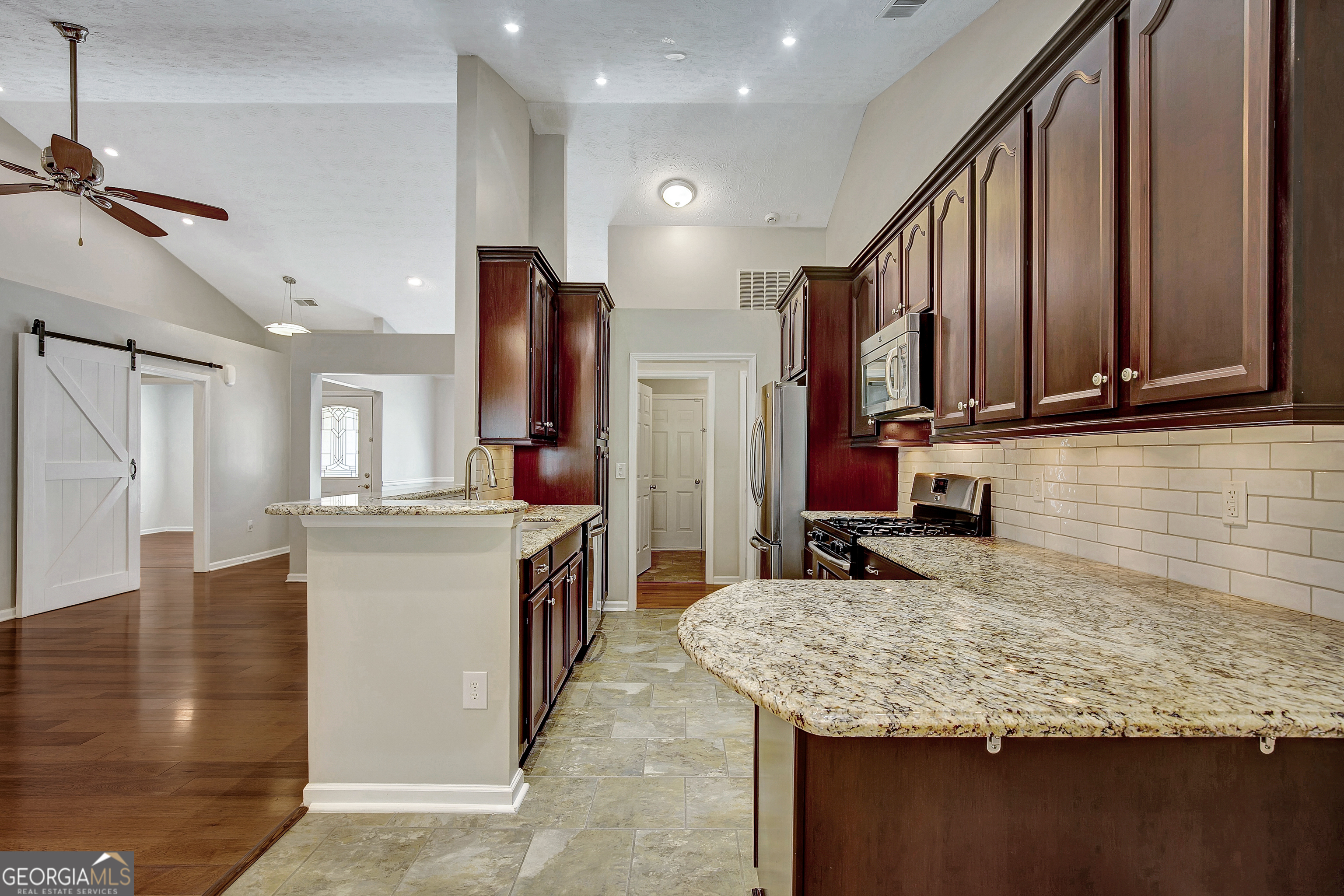 128 Lake Cove Approach Newnan, GA 30265 - Photo 32 of 63 a kitchen with stainless steel appliances granite countertop a sink refrigerator and cabinets