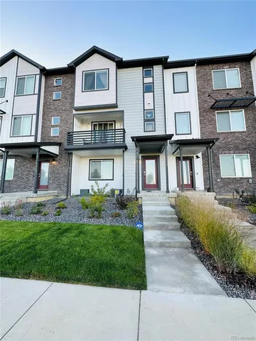 a front view of a brick house with a yard