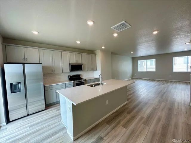 a kitchen with stainless steel appliances a refrigerator sink and microwave