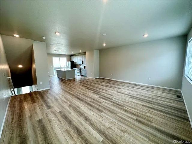 a view of empty room with wooden floor