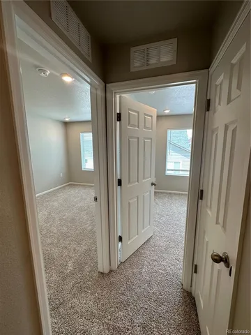 a view of a hallway with wooden floor and closet