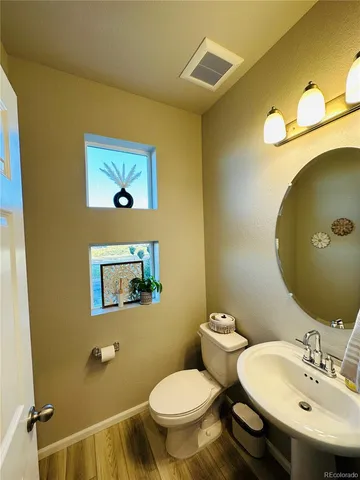 a bathroom with a toilet a sink and mirror
