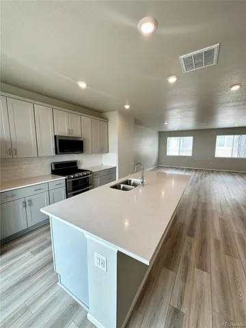 a large white kitchen with wooden floor