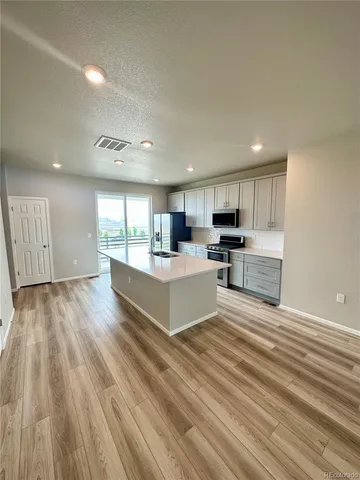 a view of kitchen with wooden floor and electronic appliances