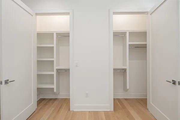 a view of walk in closet with wooden floor