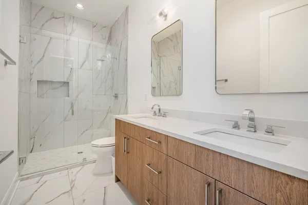 a bathroom with a sink a toilet and shower