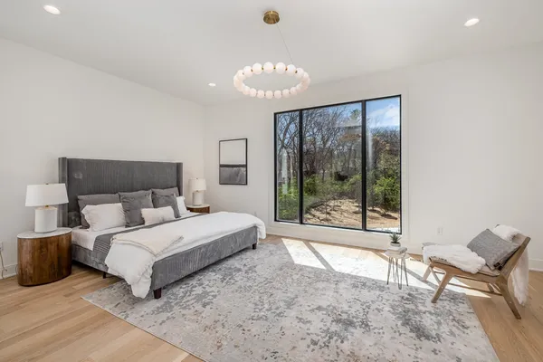 a spacious bedroom with a bed and a large window