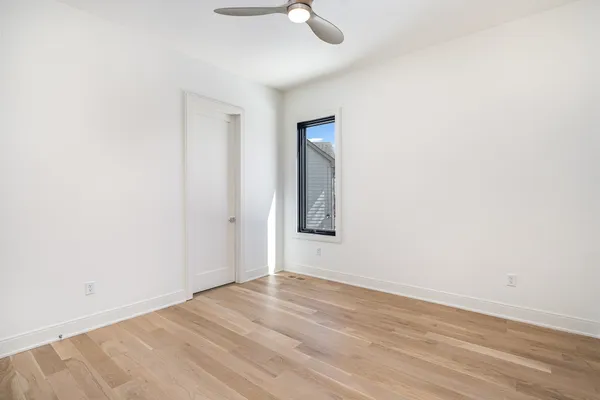 an empty room with wooden floor cabinet and closet