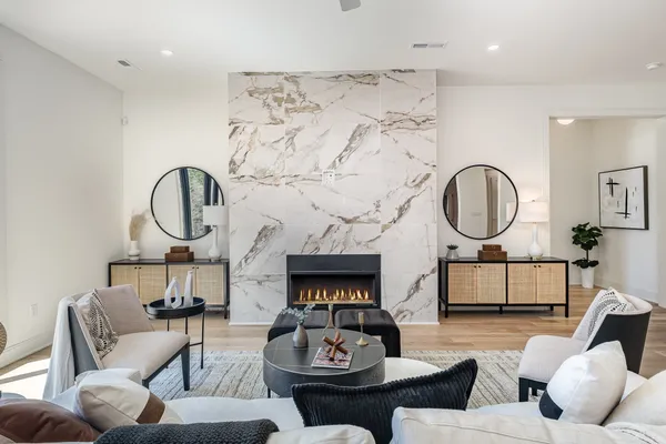 a living room with furniture a mirror and a fireplace