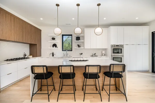 a kitchen with a dining table chairs and white cabinets