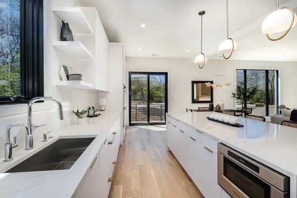 a large kitchen with granite countertop a sink and a stove top oven
