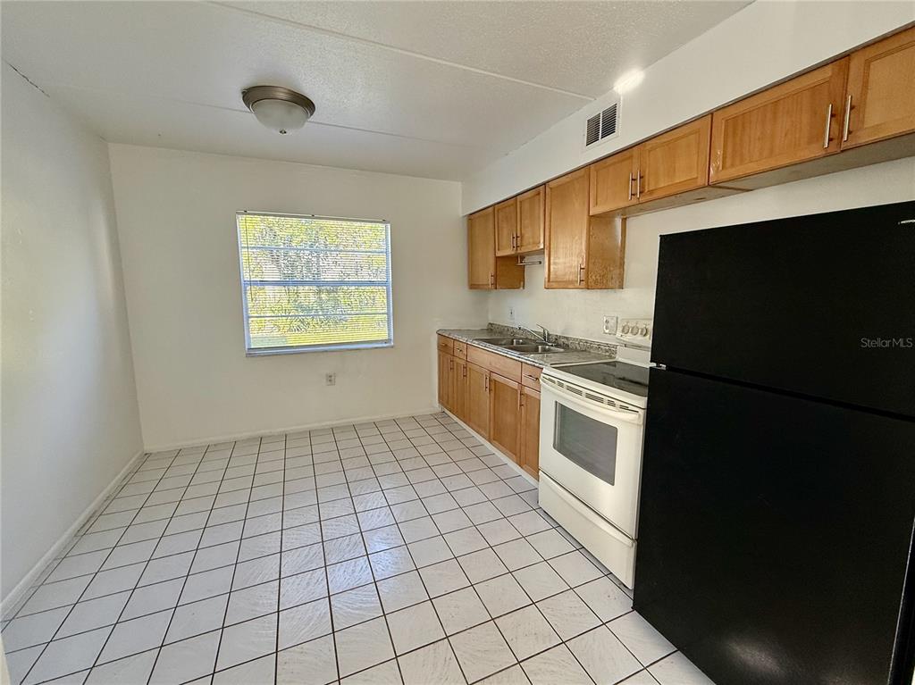 716 Michigan Court, Unit 2 St. Cloud, FL 34769 - Photo 4 of 17 a kitchen with a stove a sink and a refrigerator
