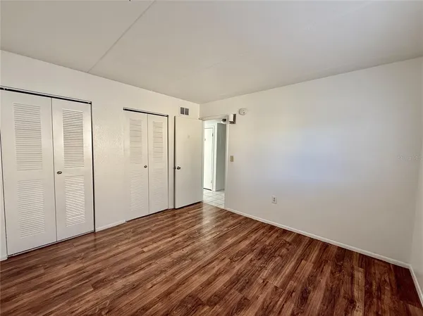 a view of an empty room with wooden floor