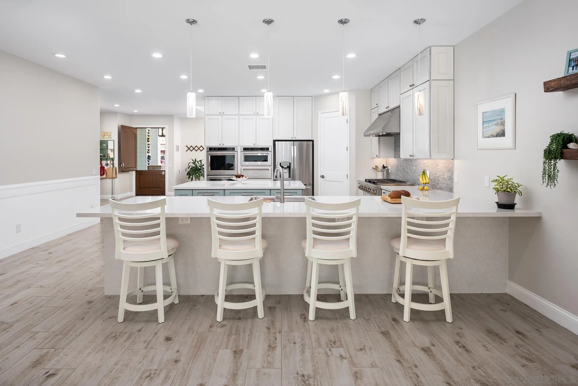 1060 Pine Street Coronado, CA 92118 - Photo 14 of 36 a kitchen with stainless steel appliances kitchen island granite countertop a dining table chairs refrigerator and microwave