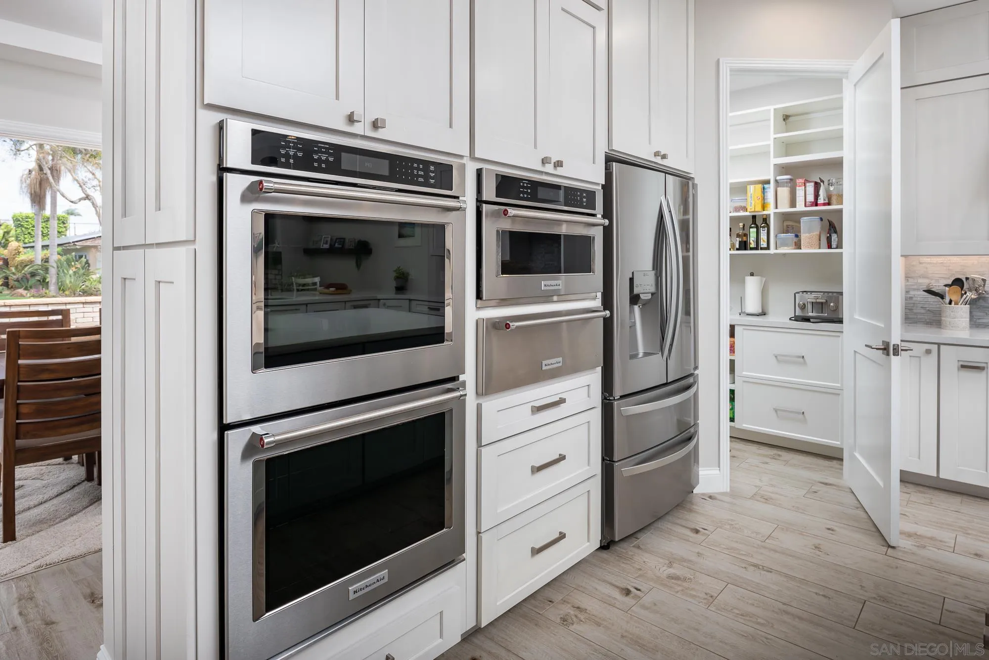 1060 Pine Street Coronado, CA 92118 - Photo 18 of 36 a kitchen with stainless steel appliances white cabinets and wooden floors