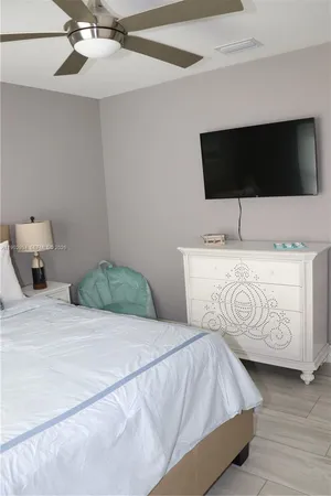 a bedroom with a bed and flat screen tv