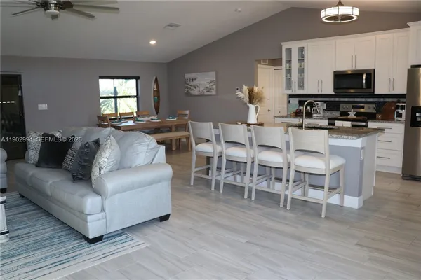 a living room with furniture a wooden floor and a flat screen tv