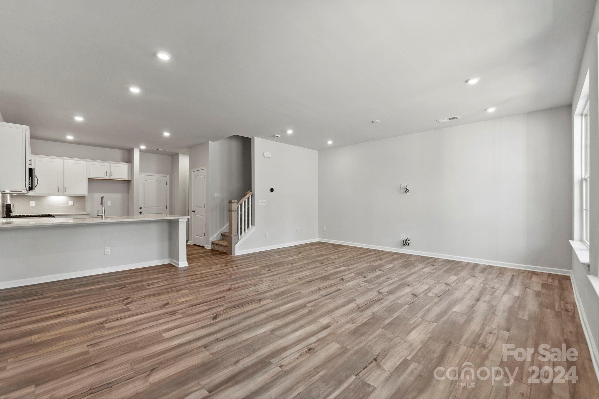 7864 Nelson Road Mint Hill, NC 28227 - Photo 20 of 45 a view of an empty room with wooden floor and kitchen