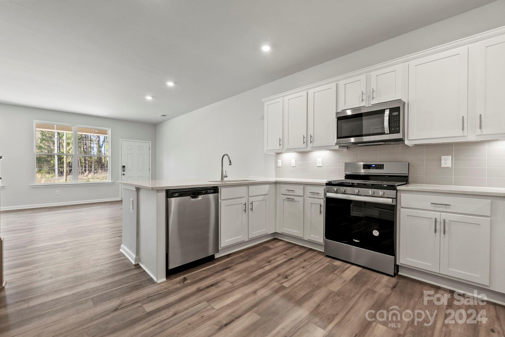 7864 Nelson Road Mint Hill, NC 28227 - Photo 25 of 45 a kitchen with granite countertop white cabinets and stainless steel appliances