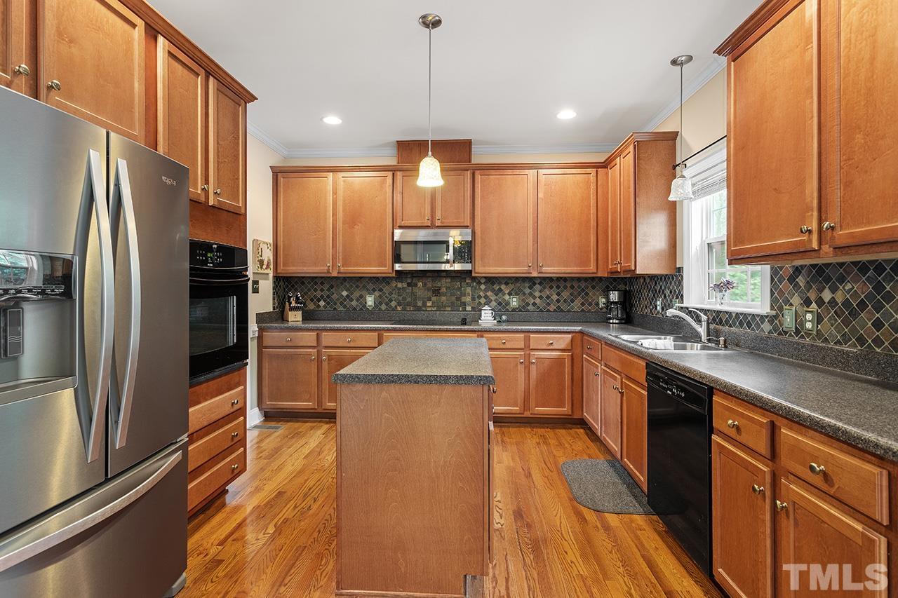 206 Kendall Drive Clayton, NC 27520 - Photo 11 of 34 a kitchen with stainless steel appliances a refrigerator sink and cabinets