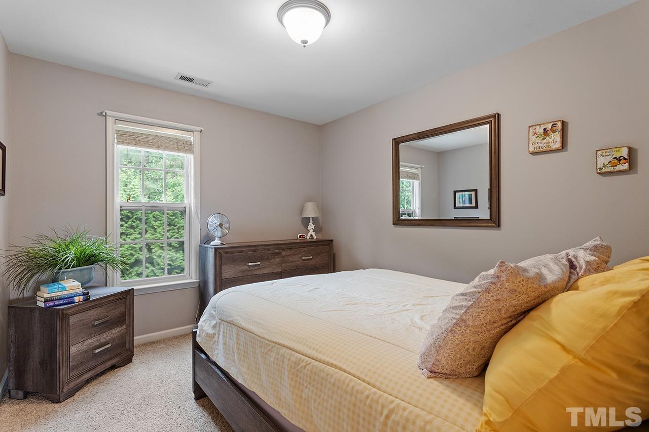 206 Kendall Drive Clayton, NC 27520 - Photo 19 of 34 a bedroom with a bed and a potted plant