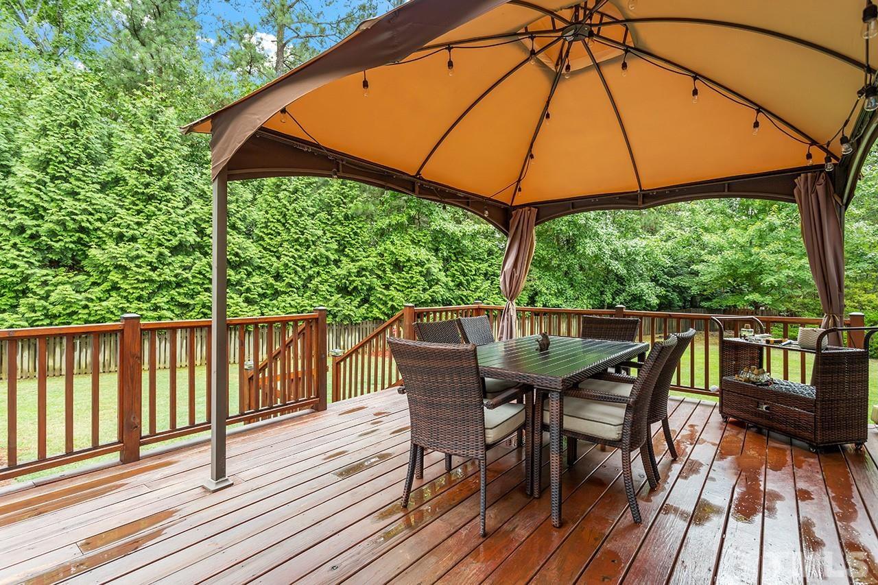 206 Kendall Drive Clayton, NC 27520 - Photo 25 of 34 a view of a deck with table and chairs under an umbrella
