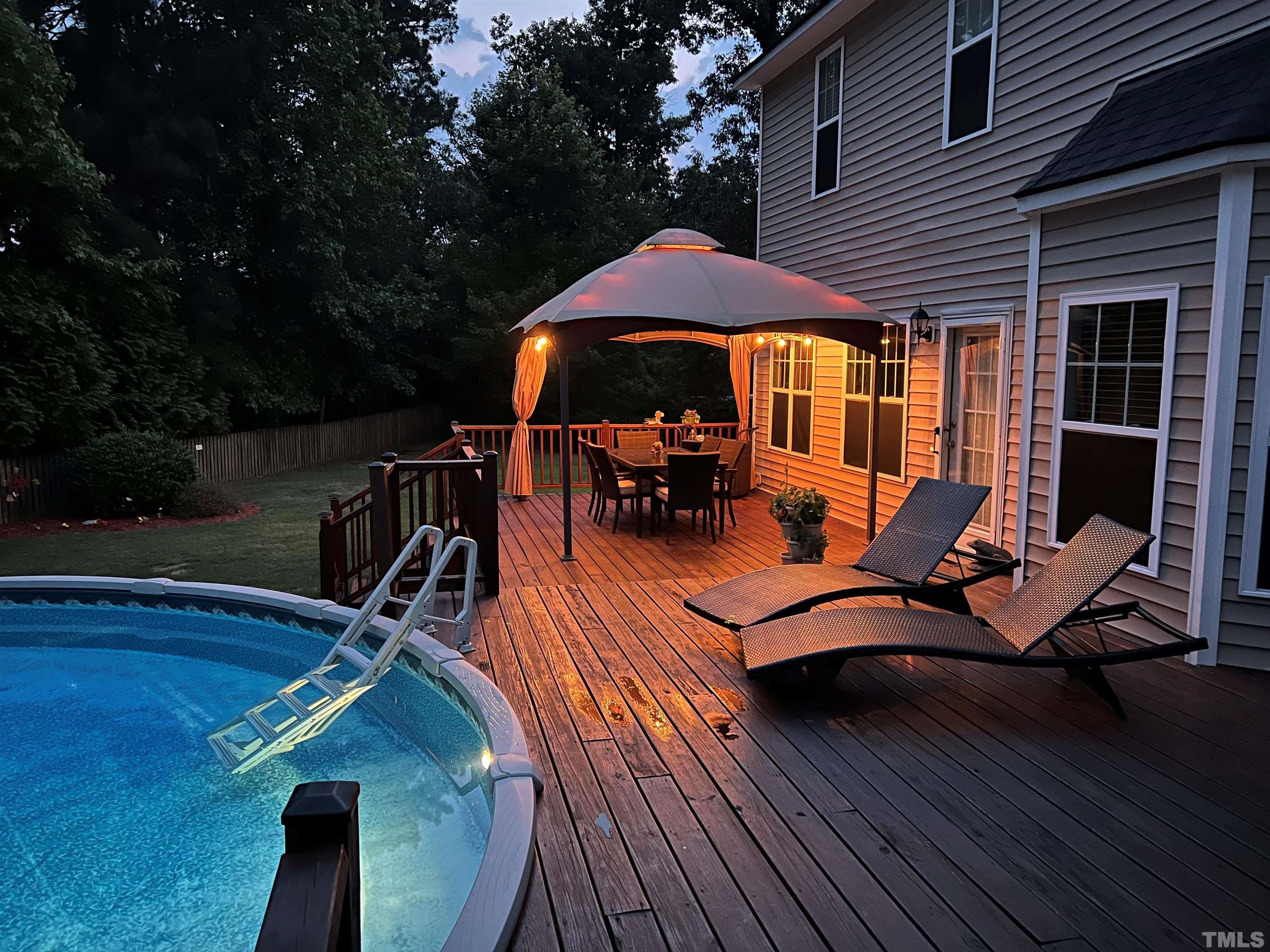 206 Kendall Drive Clayton, NC 27520 - Photo 28 of 34 a view of a patio with table and chairs under an umbrella with wooden floor