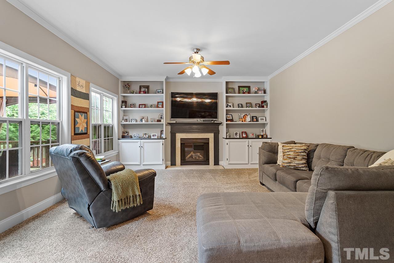 206 Kendall Drive Clayton, NC 27520 - Photo 8 of 34 a living room with furniture a fireplace and a flat screen tv