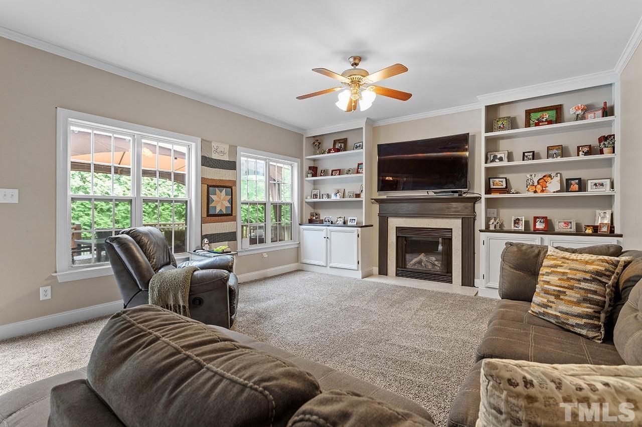 206 Kendall Drive Clayton, NC 27520 - Photo 9 of 34 a living room with furniture a fireplace and a flat screen tv