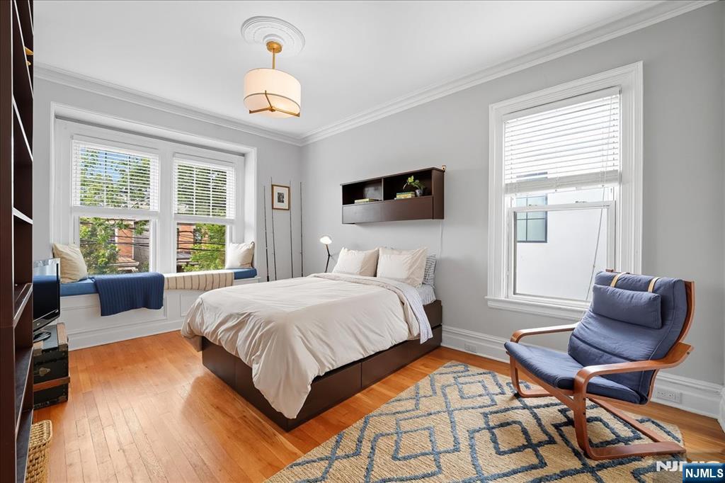 56-58 Bonn Place Weehawken, NJ 07086 - Photo 14 of 29 a bedroom with a bed and a chandelier