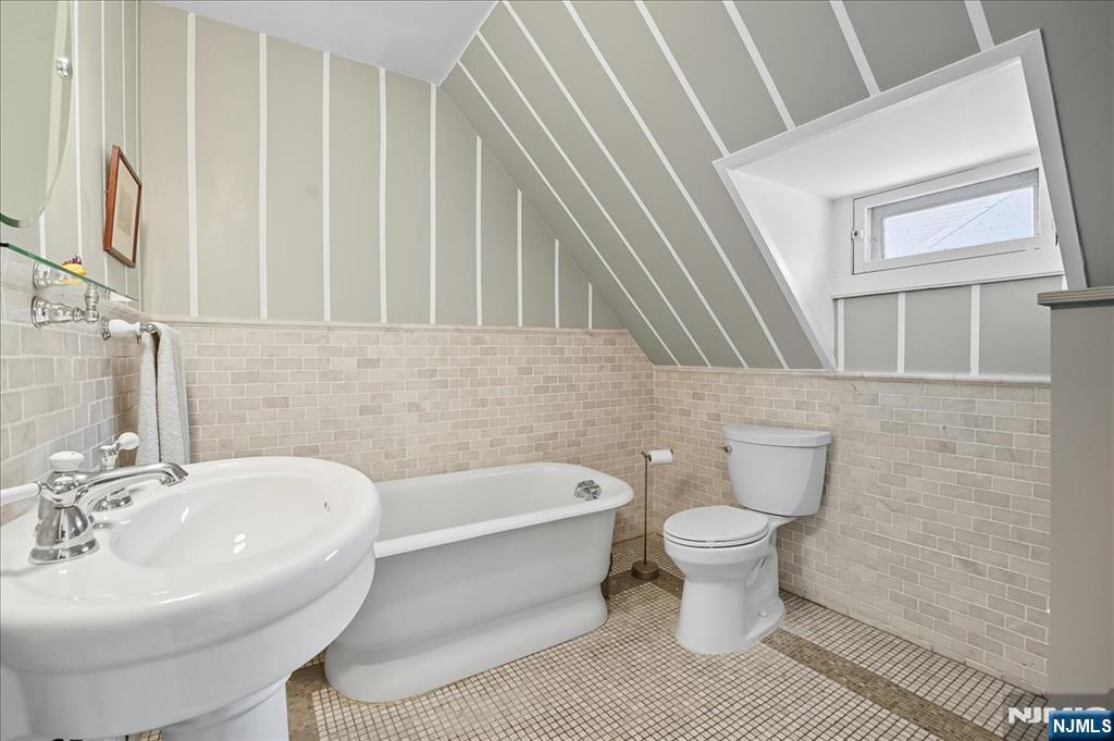 56-58 Bonn Place Weehawken, NJ 07086 - Photo 21 of 29 a bathroom with a white toilet sitting next to a white sink