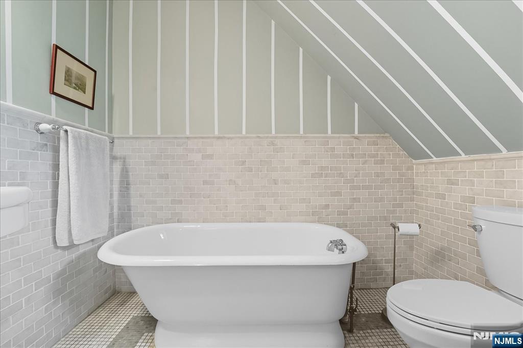 56-58 Bonn Place Weehawken, NJ 07086 - Photo 22 of 29 a white bath tub sitting next to a white toilet