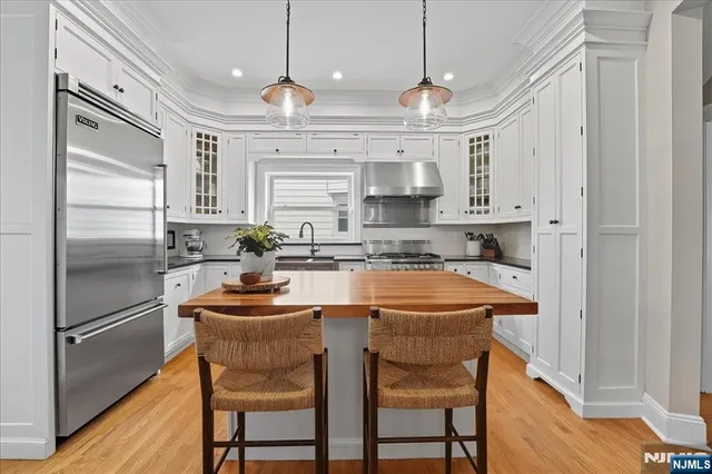 a kitchen with stainless steel appliances granite countertop a sink a stove a refrigerator and cabinets