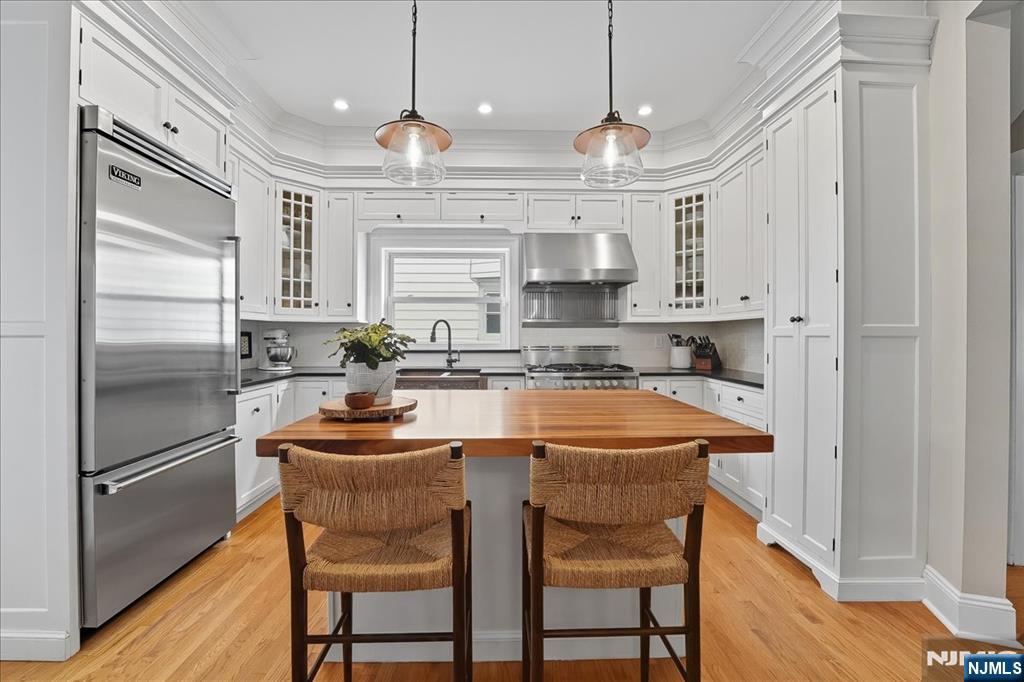 56-58 Bonn Place Weehawken, NJ 07086 - Photo 7 of 29 a kitchen with stainless steel appliances granite countertop a sink a stove a refrigerator and cabinets