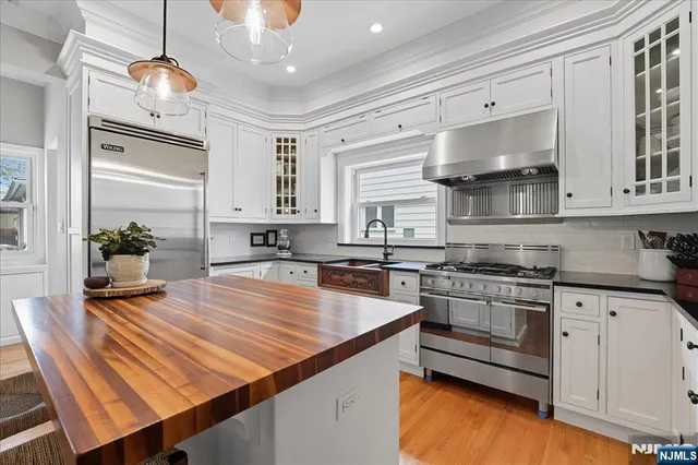 a kitchen with stainless steel appliances granite countertop a stove a sink dishwasher and cabinets with wooden floor