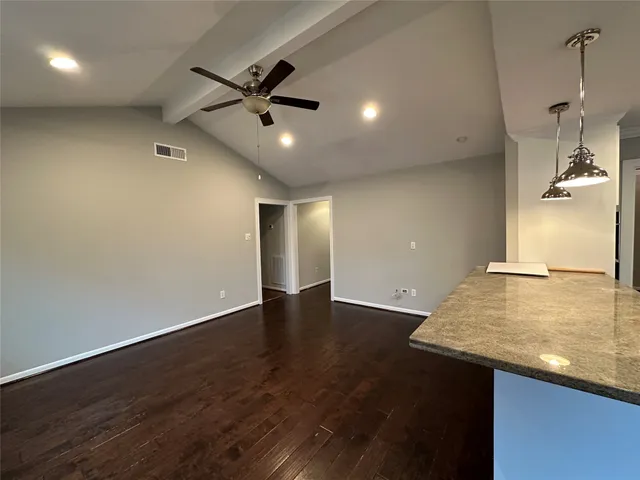 an empty room with wooden floor and window