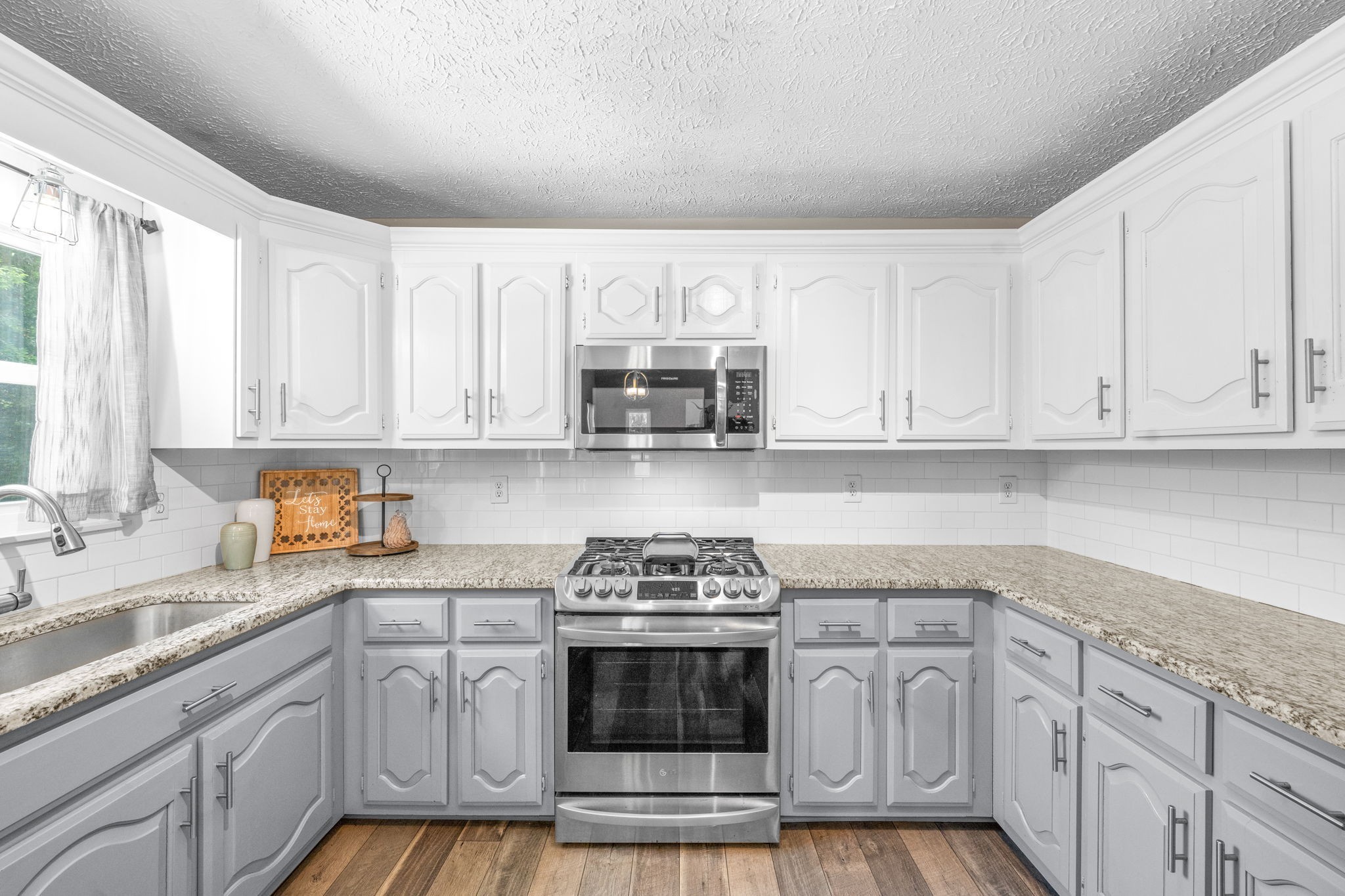4178 Highway 49 Tennessee Ridge, TN 37178 - Photo 16 of 38 a kitchen with stainless steel appliances granite countertop a stove a sink and a white cabinets